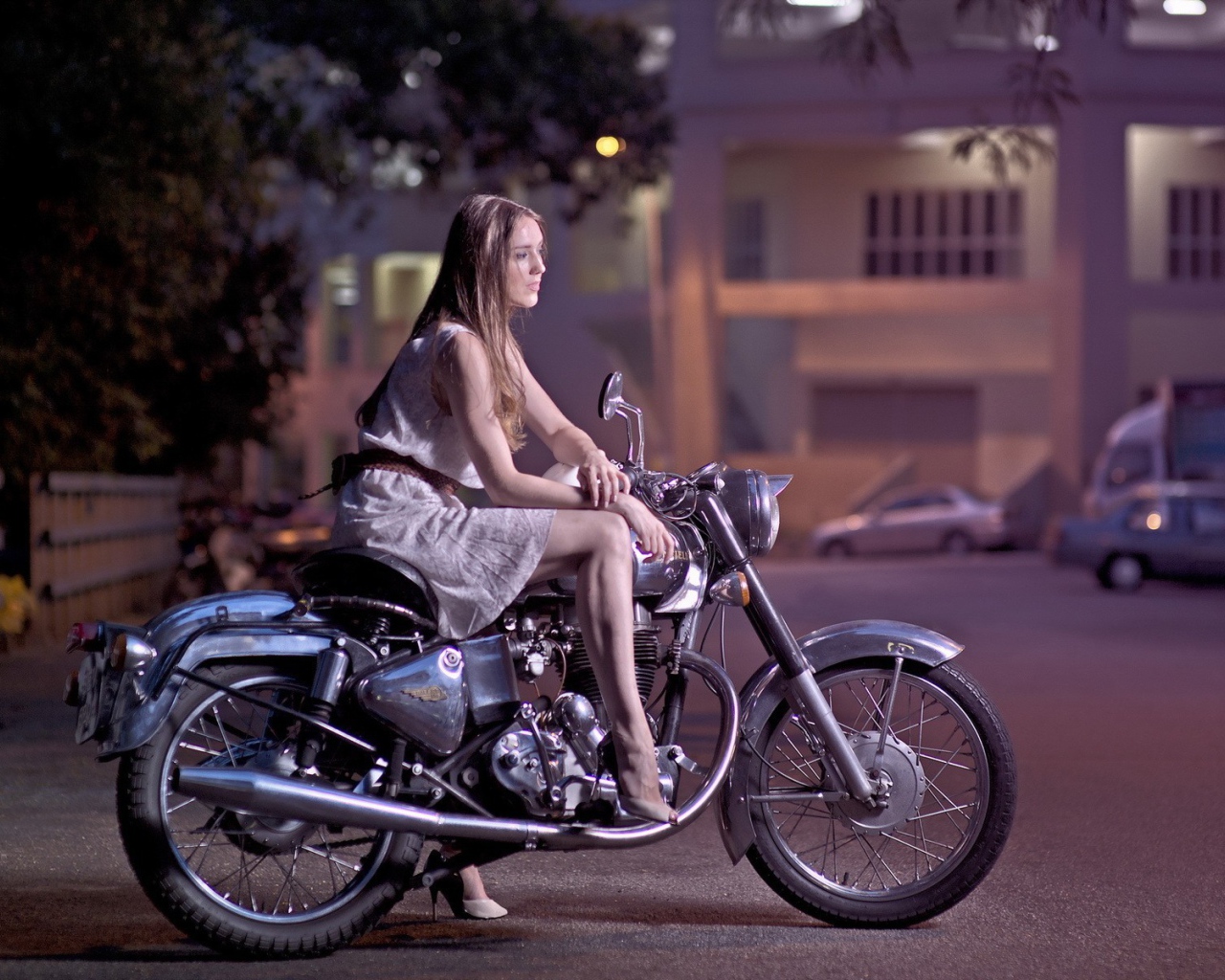 Девушка на мотоцикле стоит на парковке