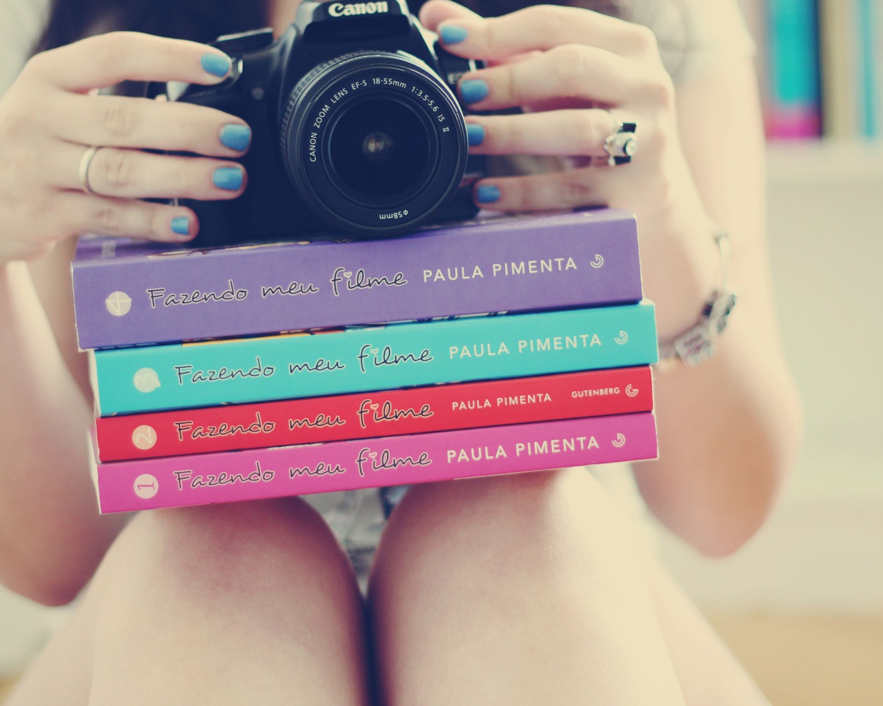 Девушка фотограф со стопкой книг