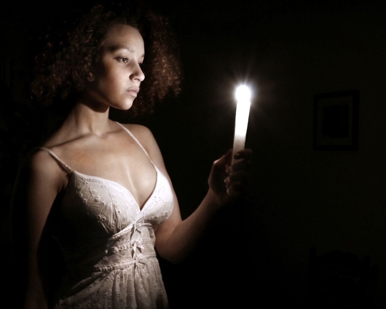 Девушка со свечой в темноте