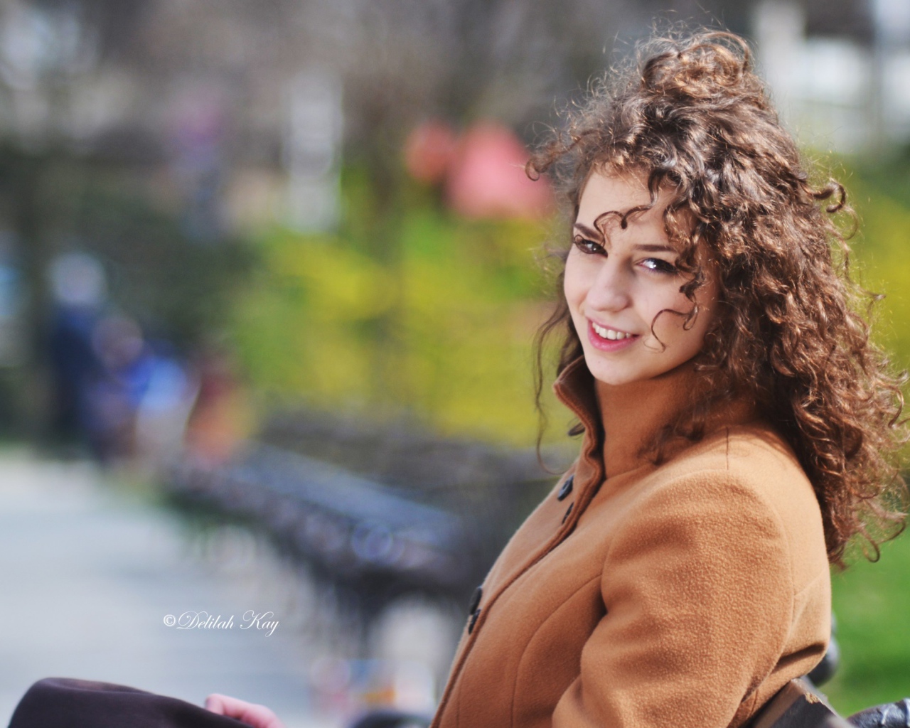 Ветер треплет волосы кучерявой девушки