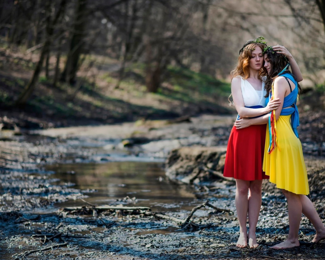 Две девушки в ярких платьях в чаще леса