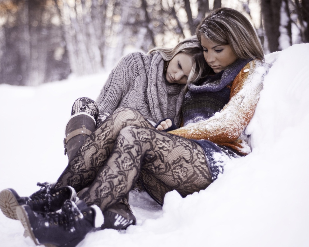 Две девушки сидят в снегу