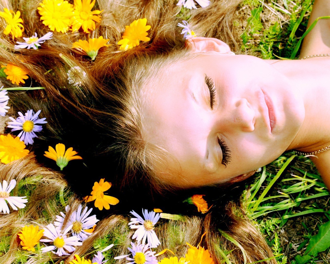 Белые и желтые цветы в волосах у девушки