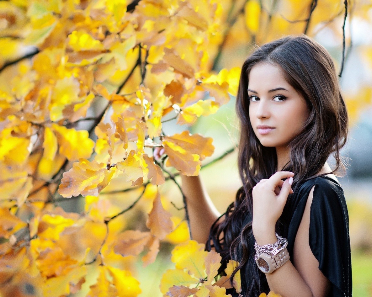 Молодая брюнетка у осеннего дерева