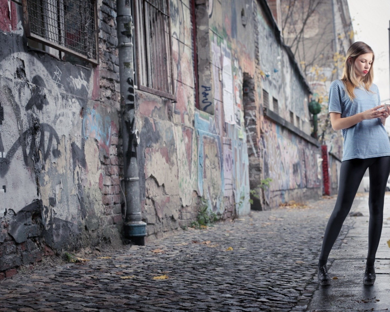 Молодая девушка стоит на улице в трущобах