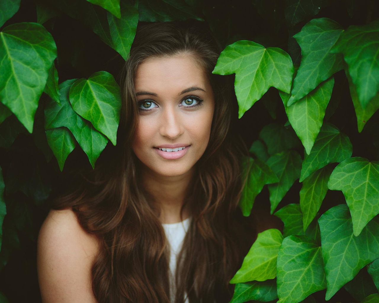 Зеленоглазая девушка модель среди листьев