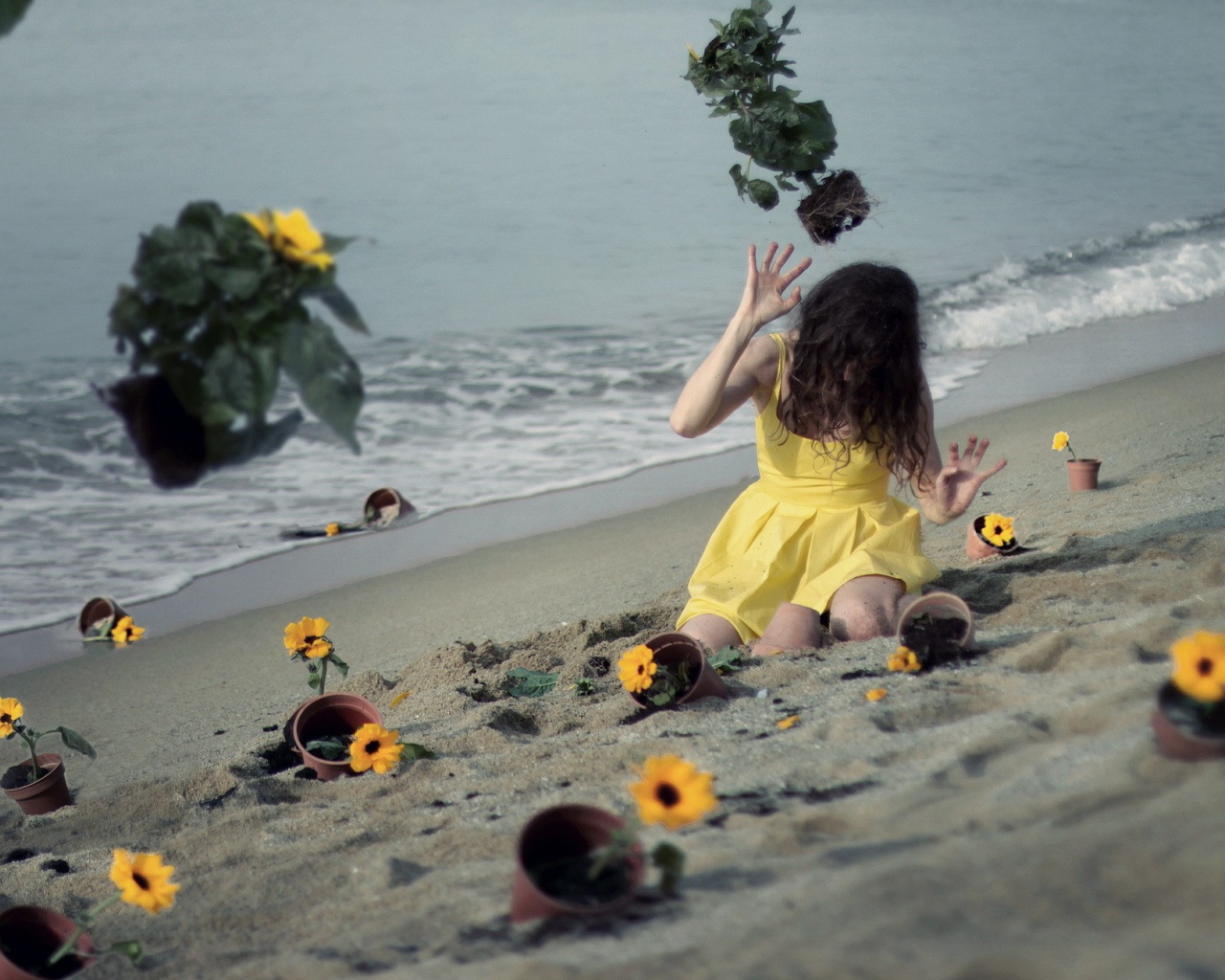 Модель в желтом платье среди цветов на пляже