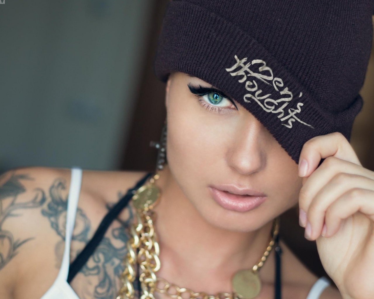 Модель с татуировками и золотой цепью на шее