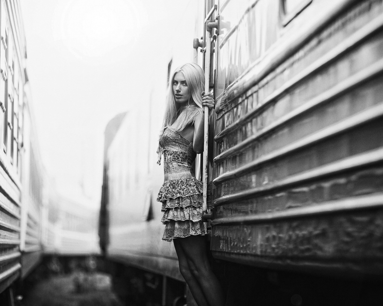 Модель стоит у входа в вагон, черно белое фото