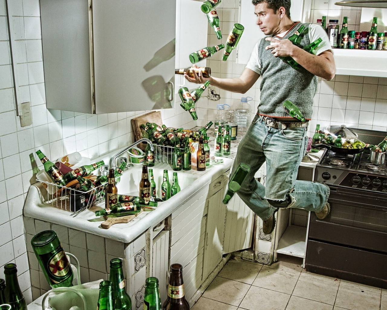 Мужчина среди бутылок пива на кухне
