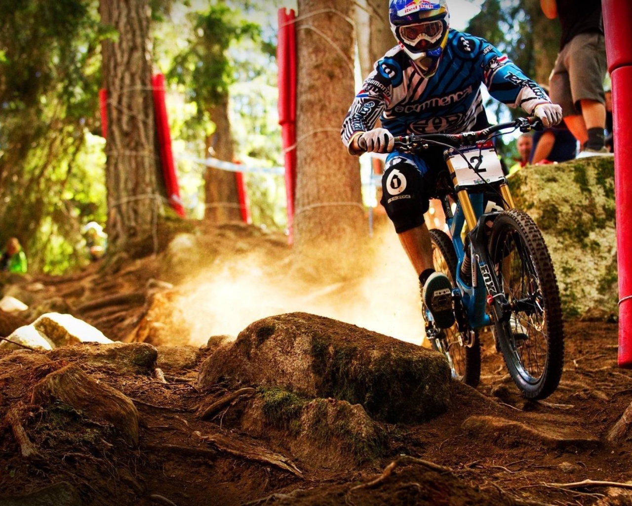 Мотобайкер объезжает камень в лесу