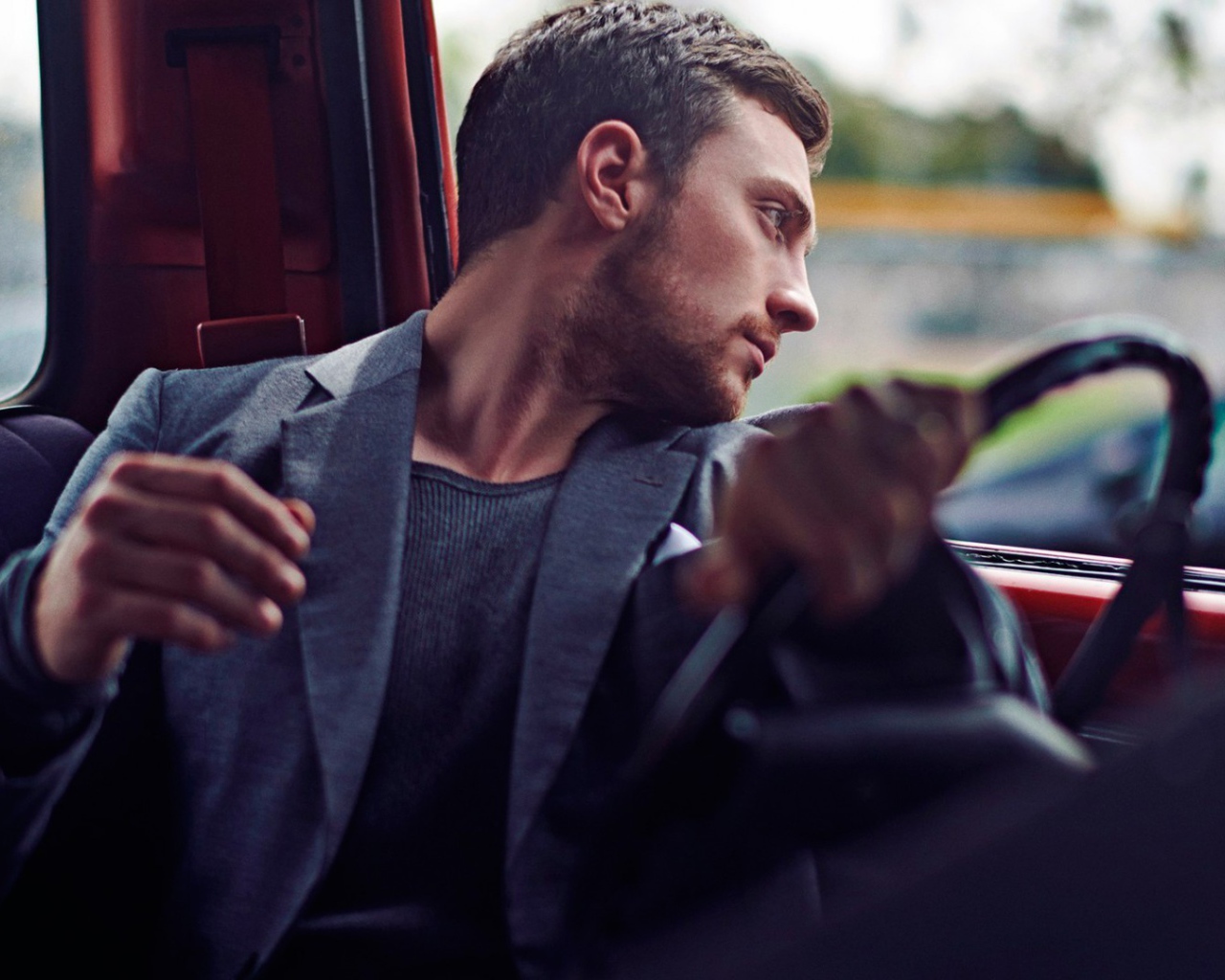 Мужчина за рулем смотрит в окно автомобиля