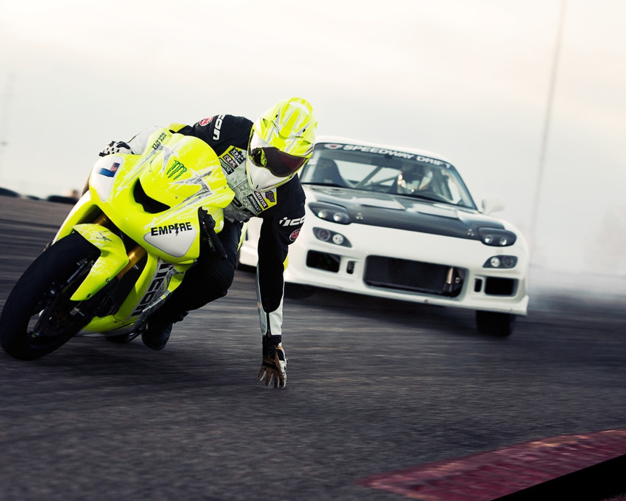 Мотоциклист касается рукой поверхности трека