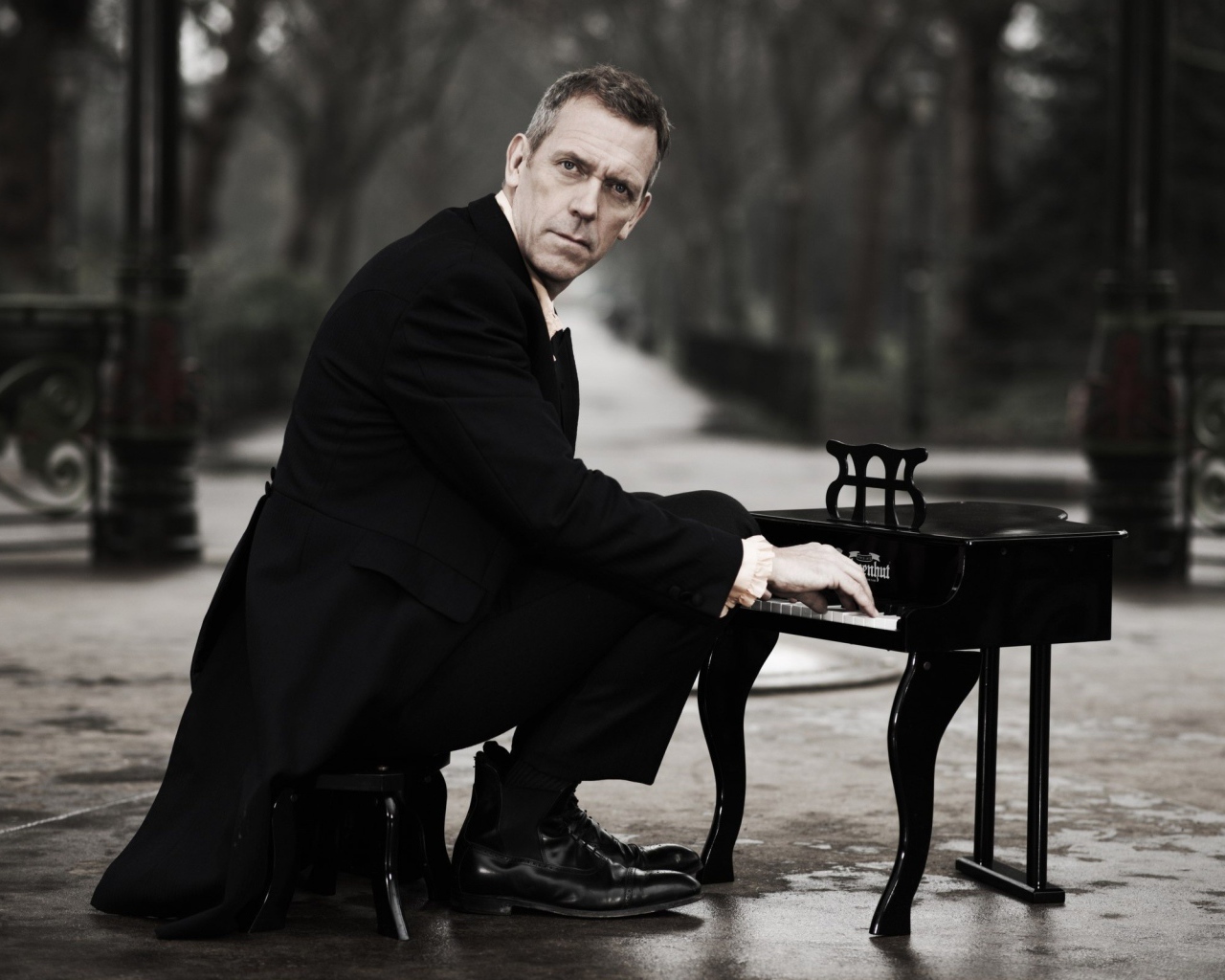 Мужчина играет на крошечном рояле