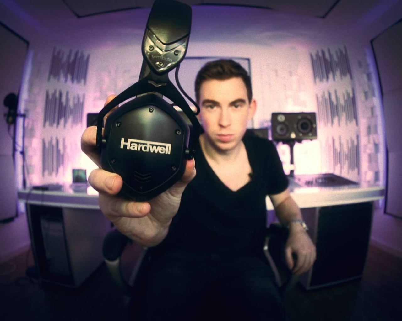 Музыкант держит в руке наушники Hardwell