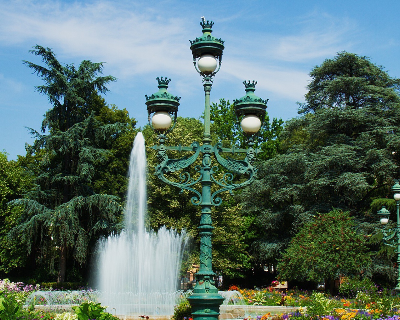 Зеленый чугунный фонарь в парке