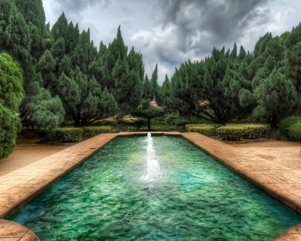 Пруд с фонтанами в саду