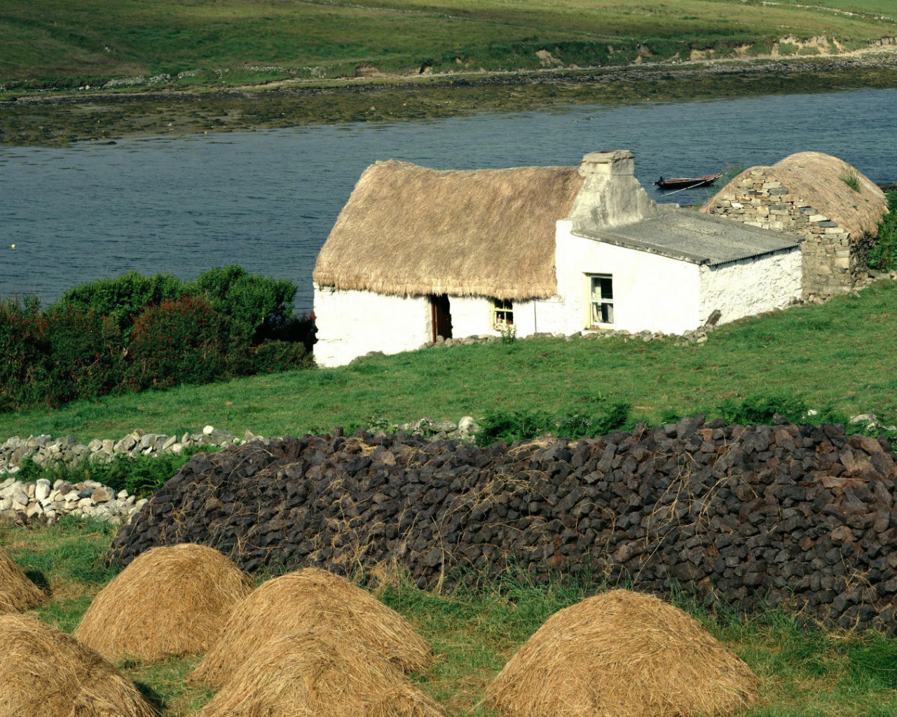 Покрытый соломой дом на берегу реки