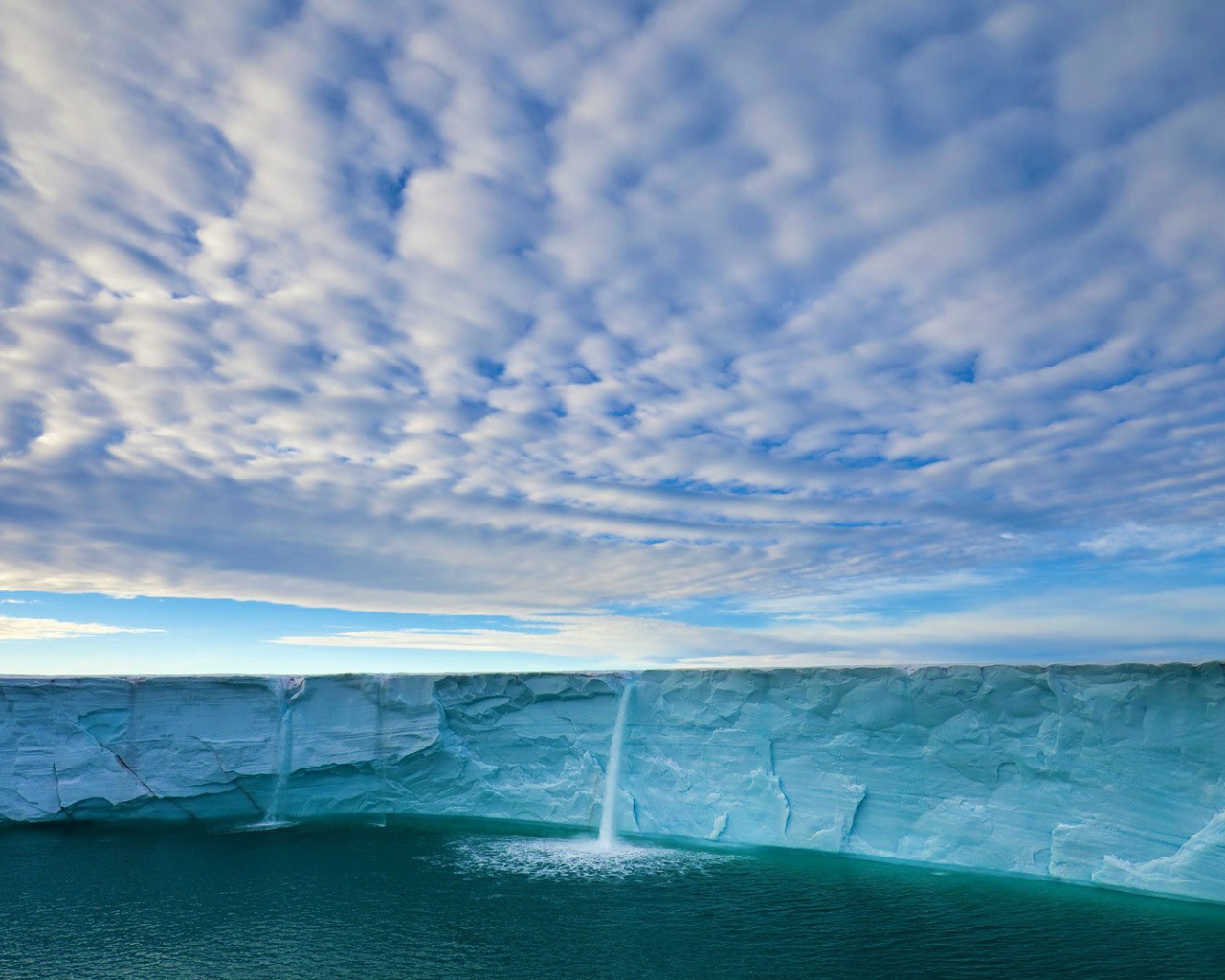 Вода стекает с края ледника