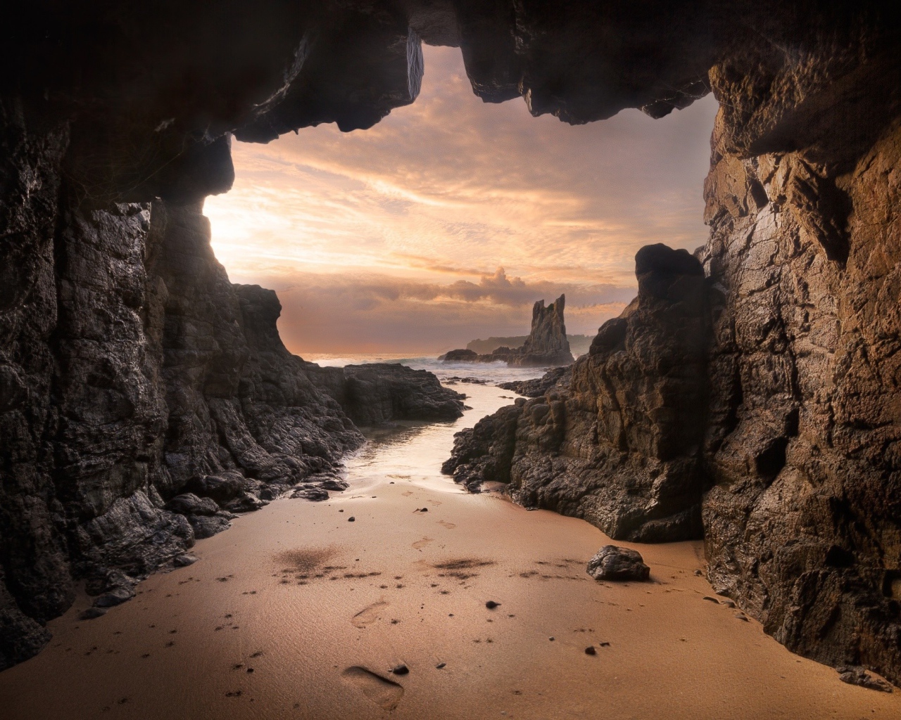 Мокрый песок у входа в пещеру