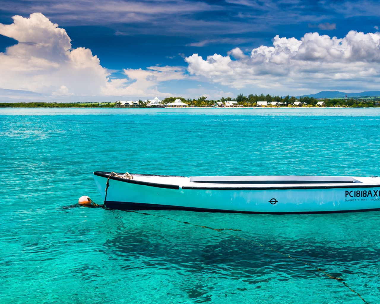 Белая лодка на голубой прозрачной воде