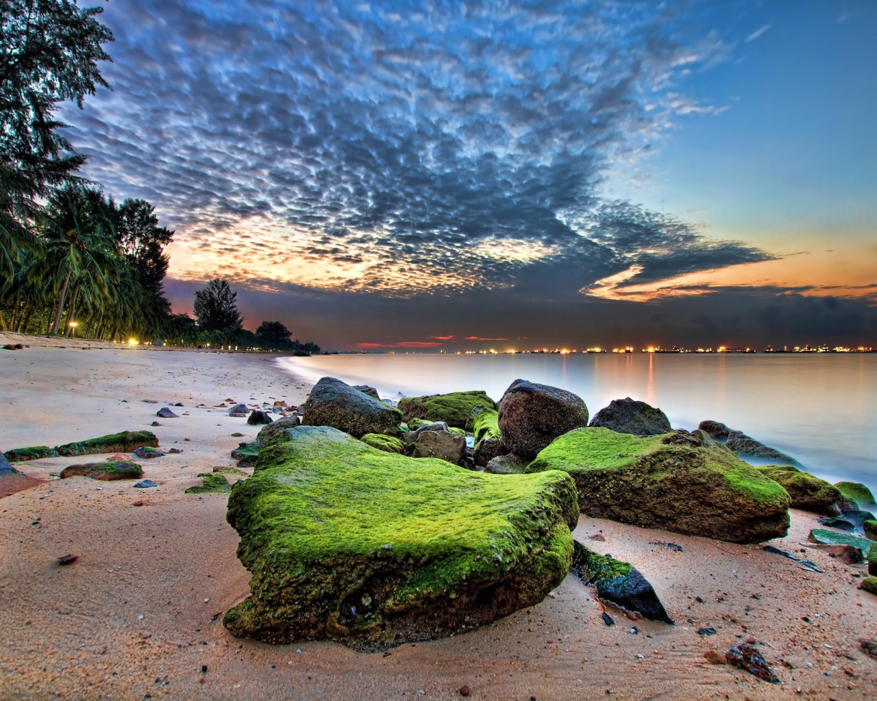 Зеленые камни на песке пляжа