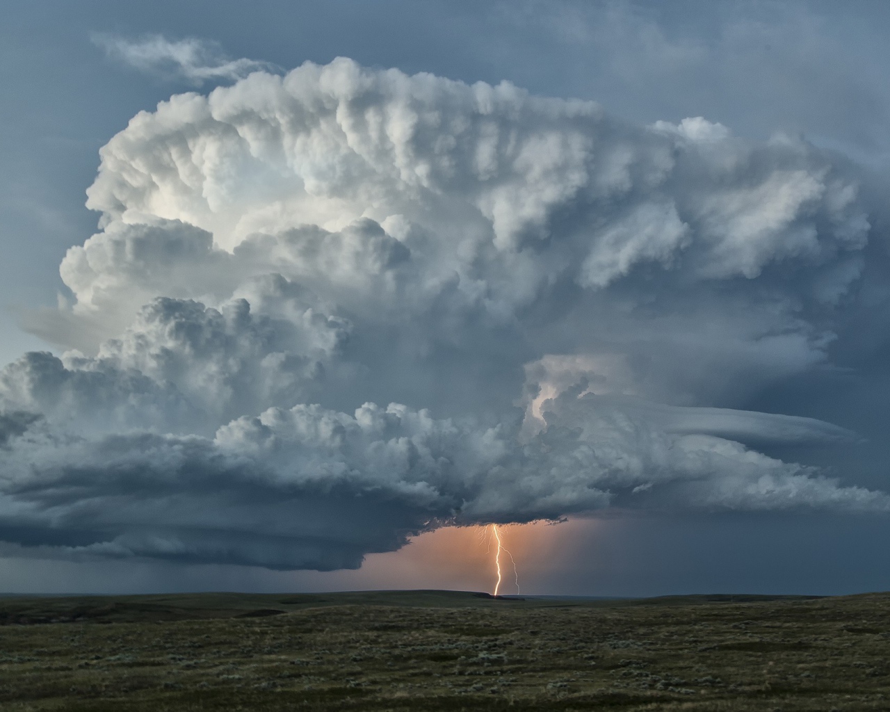 Оранжевая молния в огромном белом облаке