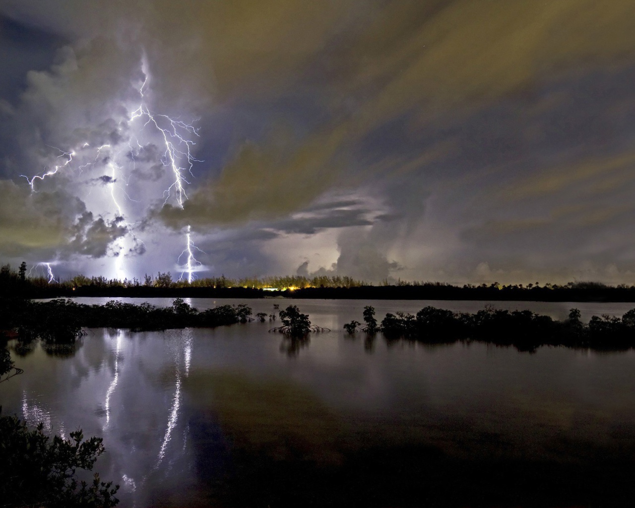 Молнии грозы отражаются в озере