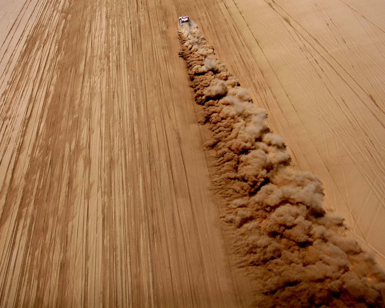 Облако пыли за автомобилем в пустыне