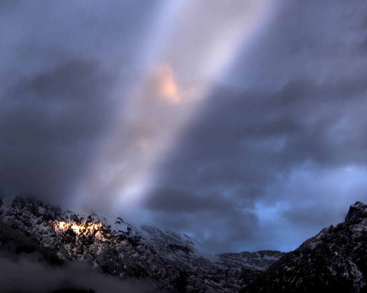 Луч солнца среди облаков в горах