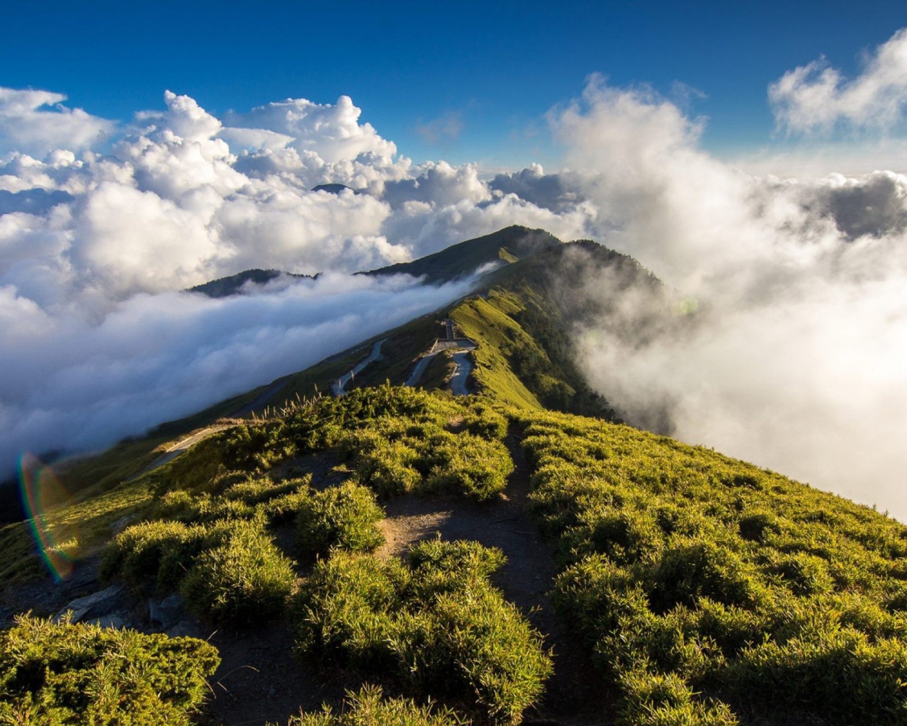 Зеленый горный хребет среди облаков