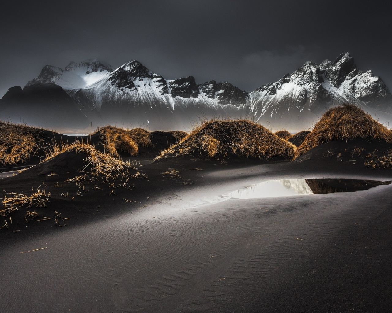 Серый песок на фоне гор