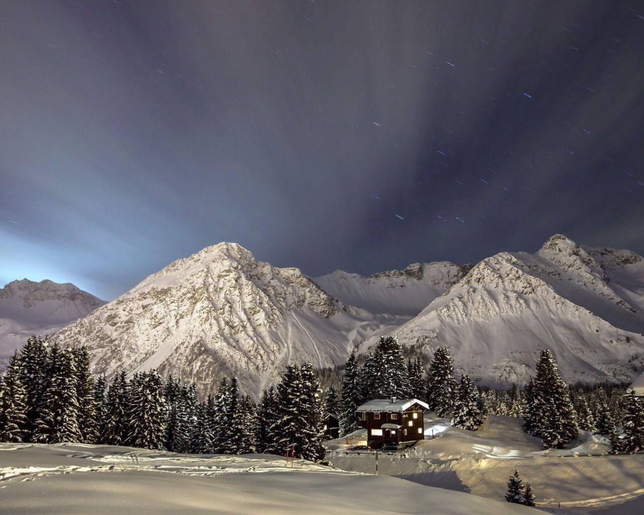Лучи света над заснеженными горами