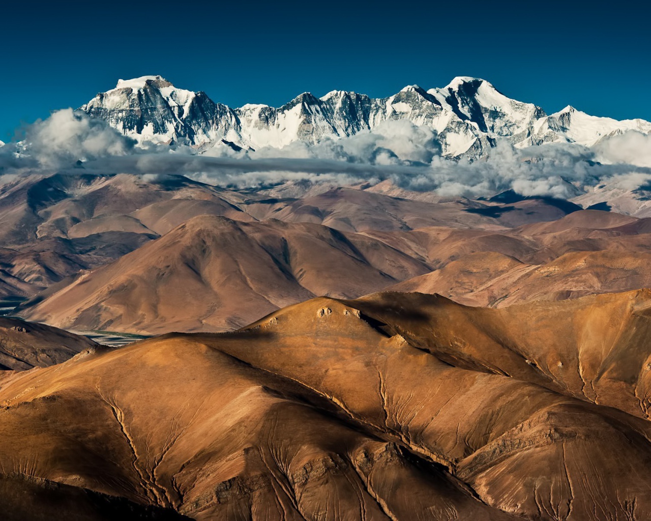 Покрытые снегом вершины высоких гор над плоскогорьем