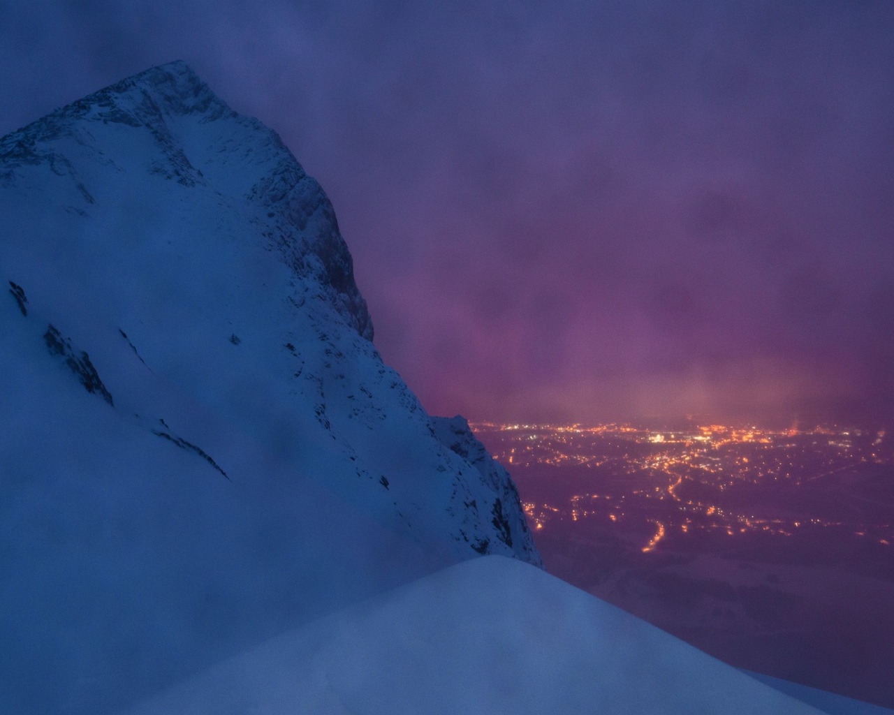 Заснеженная скала на фоне ночного города