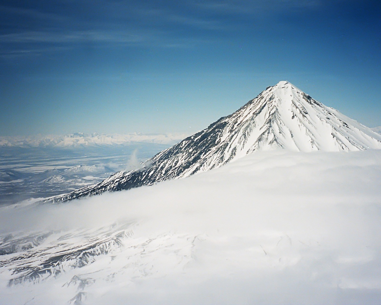 Вершина покрытой снегом горы в облаке