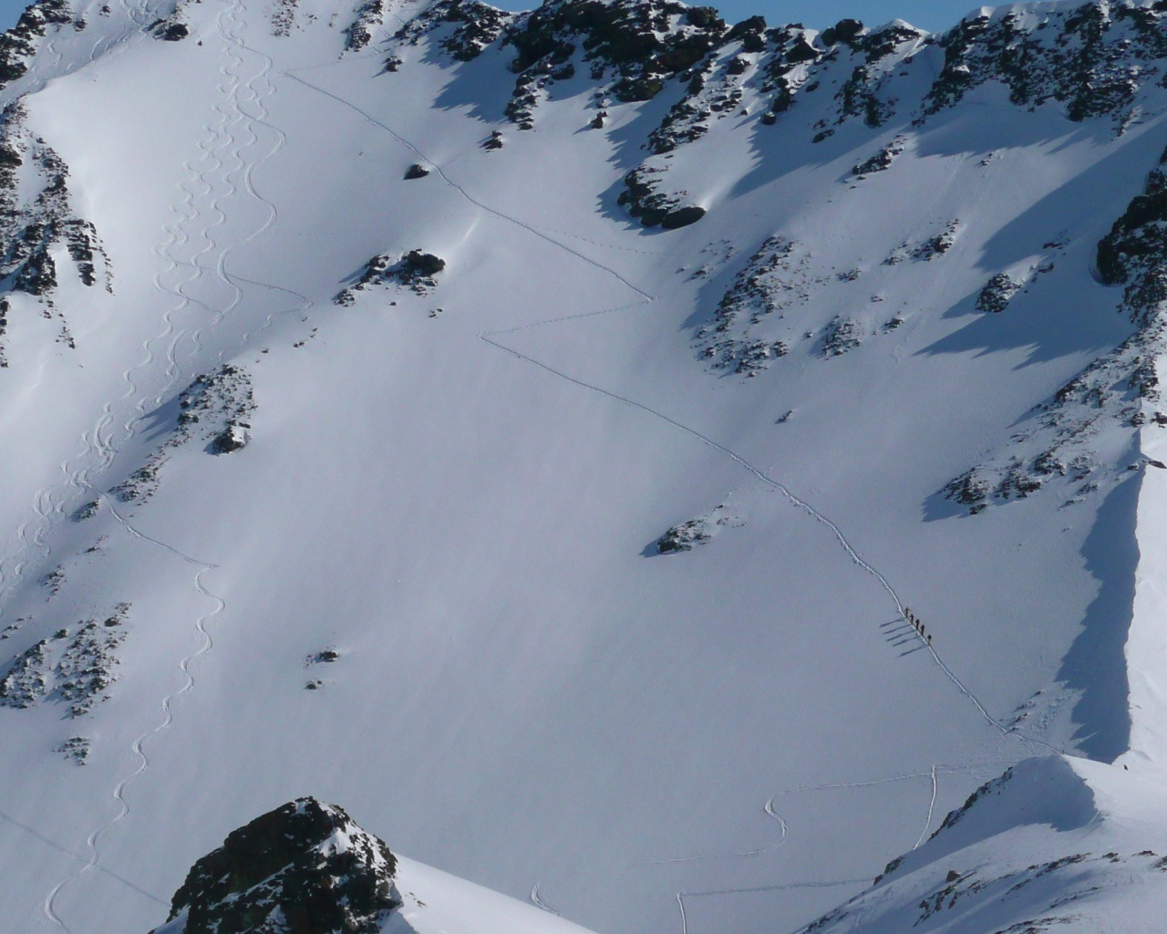 Следы лыжников на горном склоне