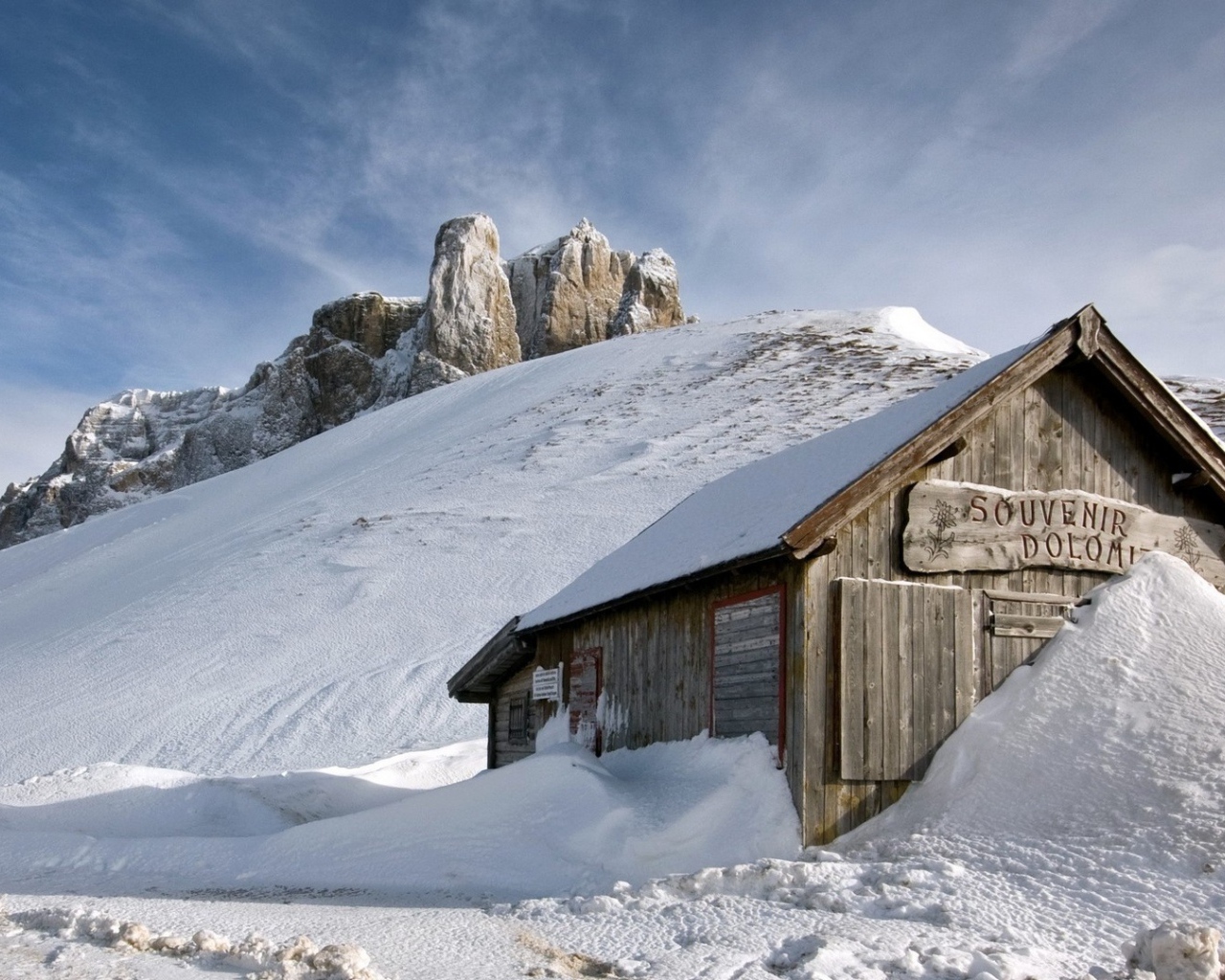 Деревянный домик замело снегом в горах