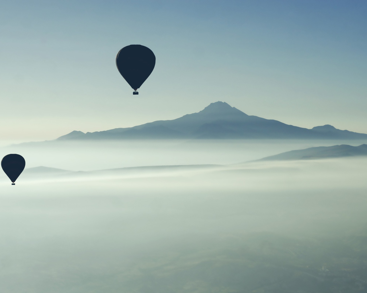 Черные воздушные шары над туманом