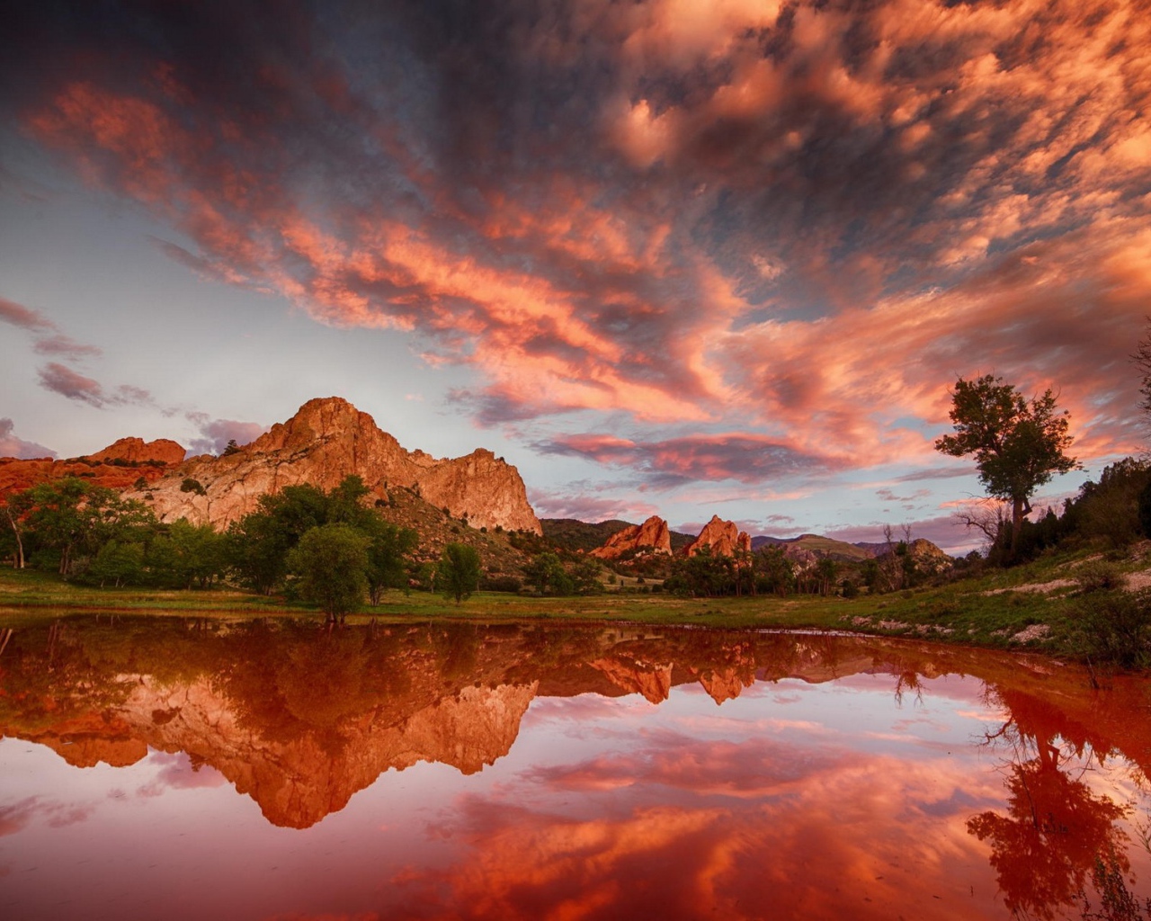 Облака отражаются в коричневой воде озера