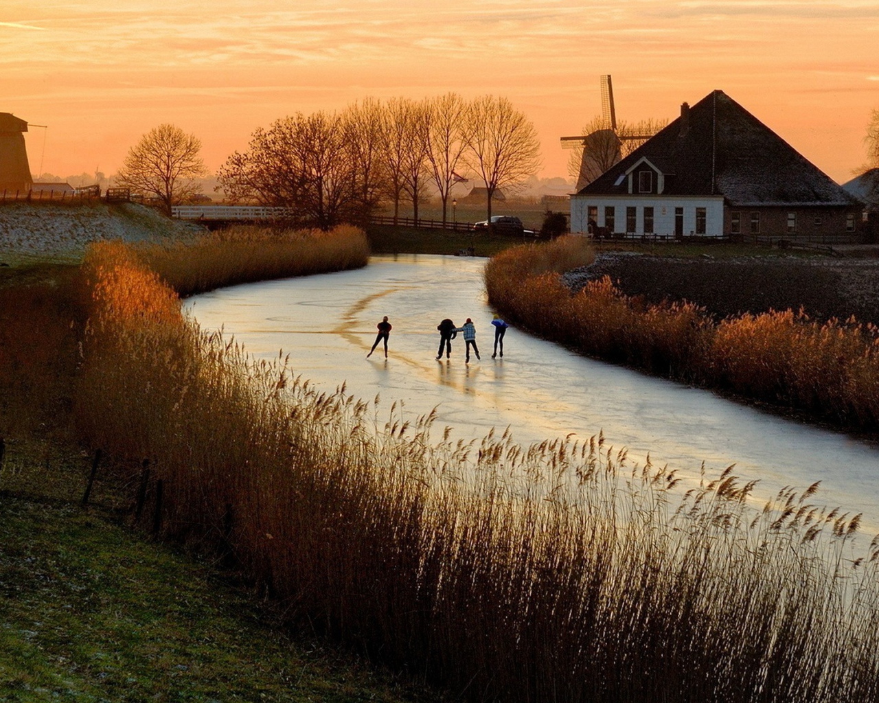 Дети катаются на коньках по замерзшей реке в Нидерландах