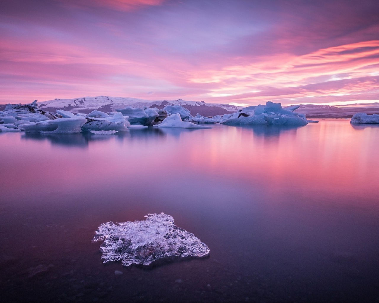 Кусочки льда на поверхности розового озера
