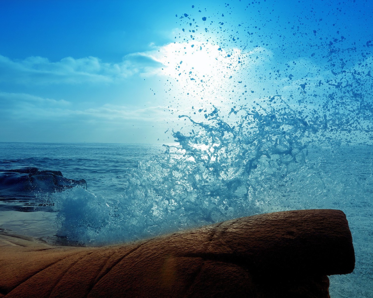 Голубая волна разбилась о камень на берегу