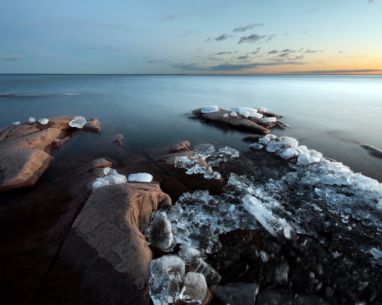 Куски льда на камнях у берега