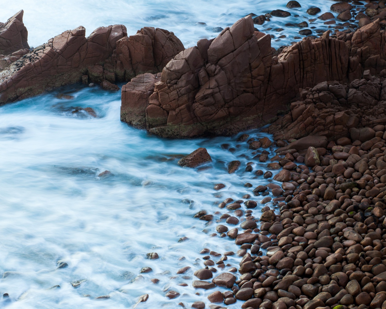 Мелкие коричневые камни на берегу моря