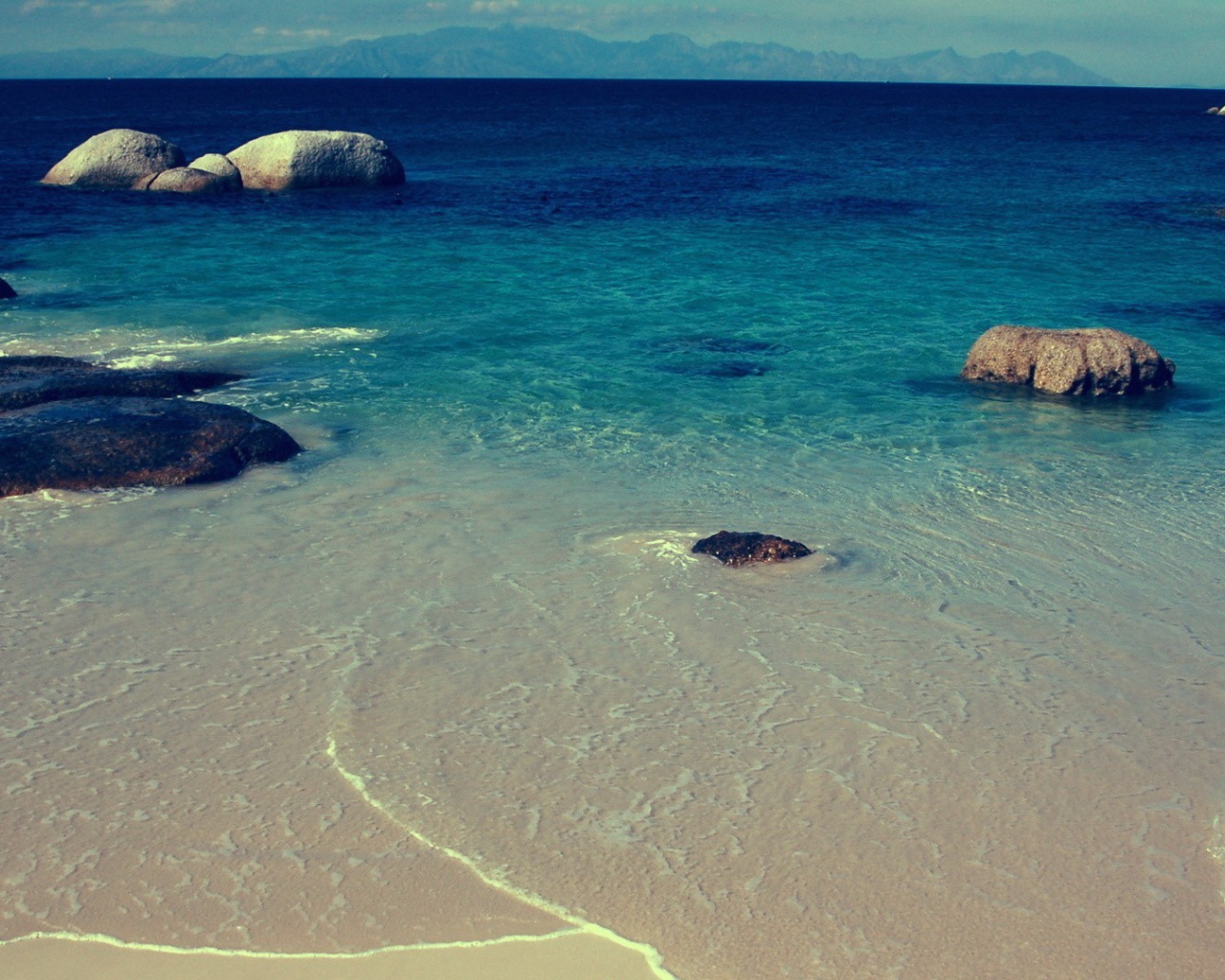 Камни в синей воде у берега моря