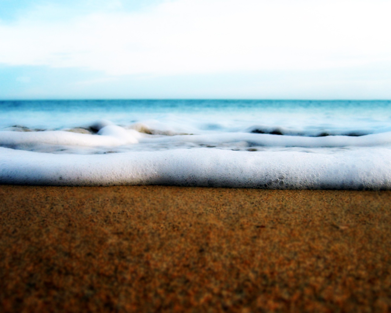 Белая пена волны у берега