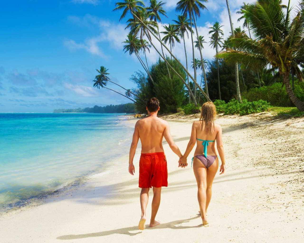 Парень и девушка идут по пляжу