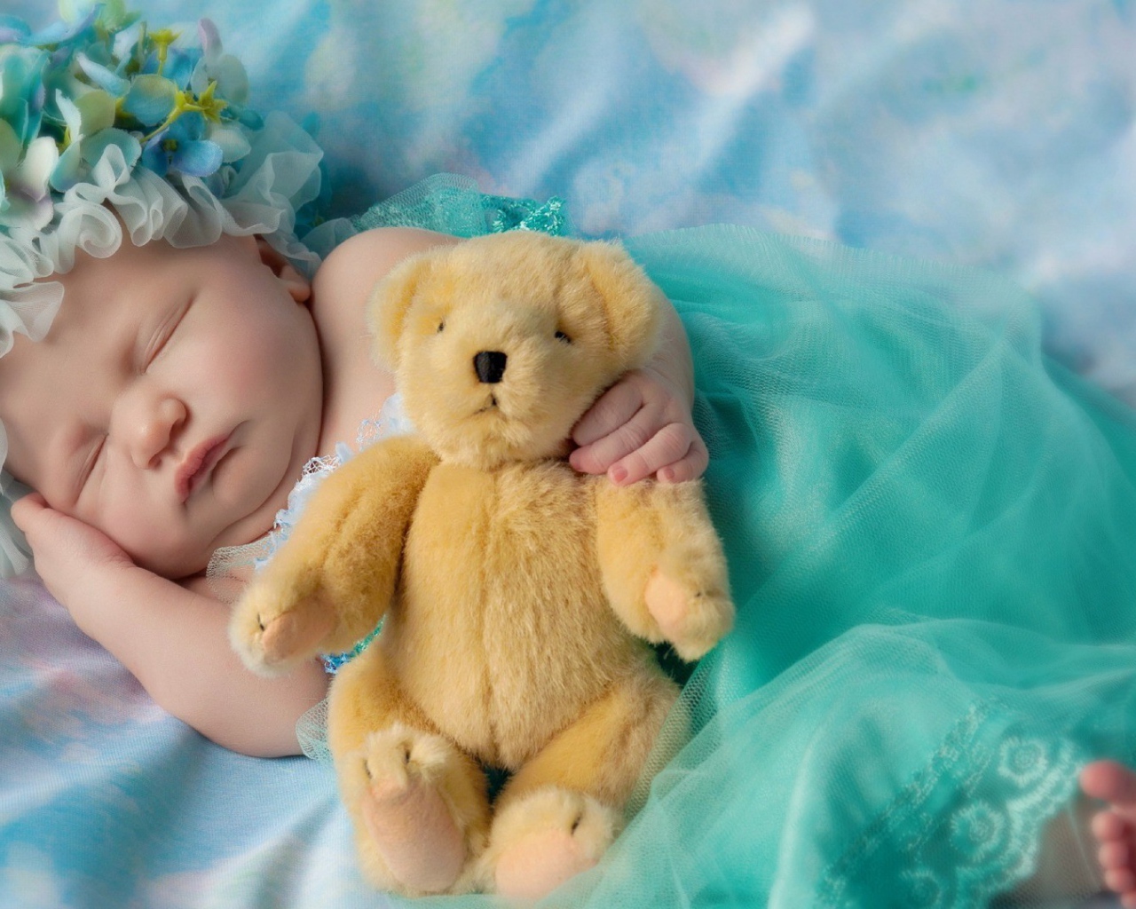 Ребенок спит с медвежонком в руке