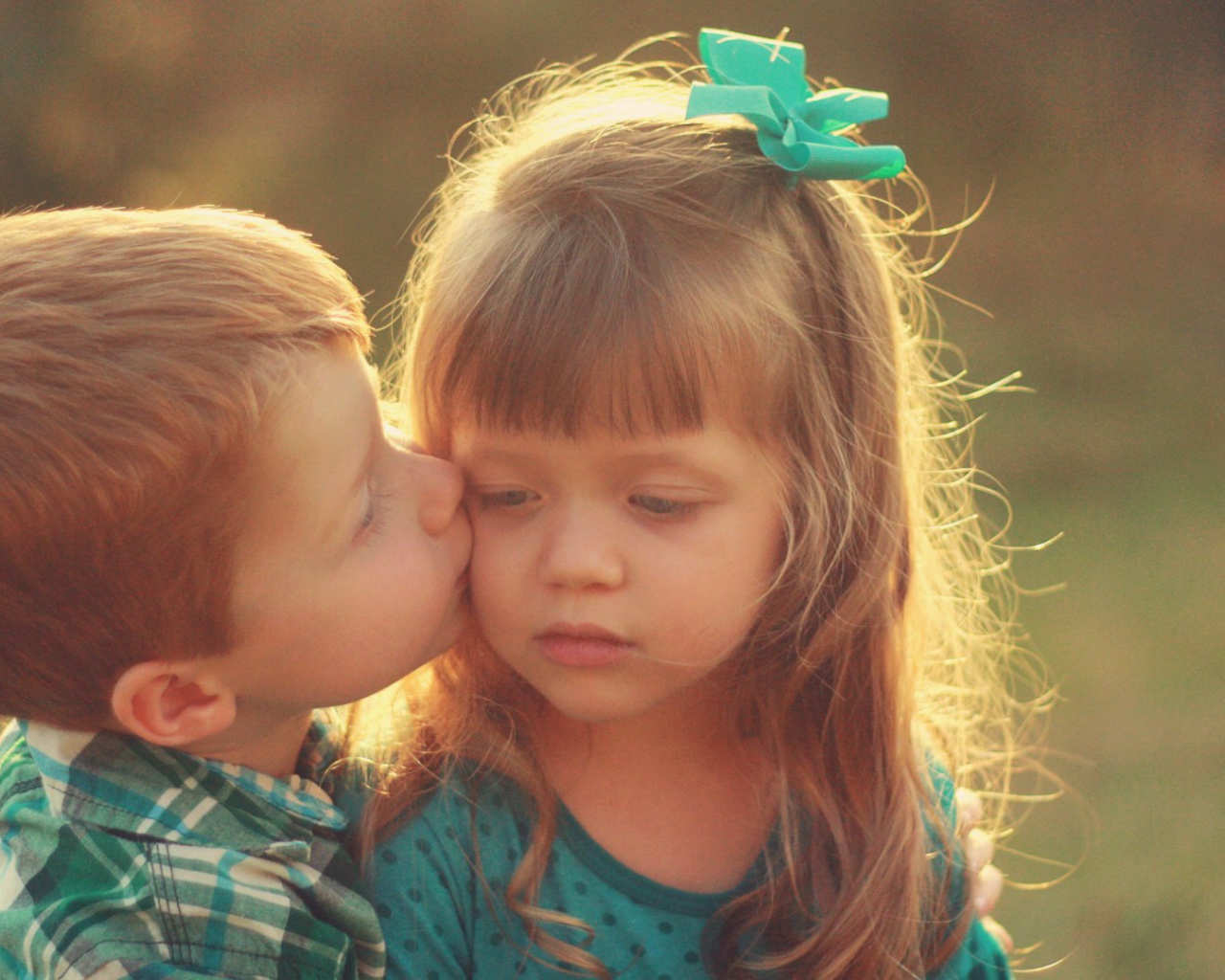 Мальчик целует сестренку в щеку